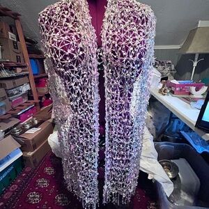 Handmade open-knit scarf with floral embellishments and subtle color variations.